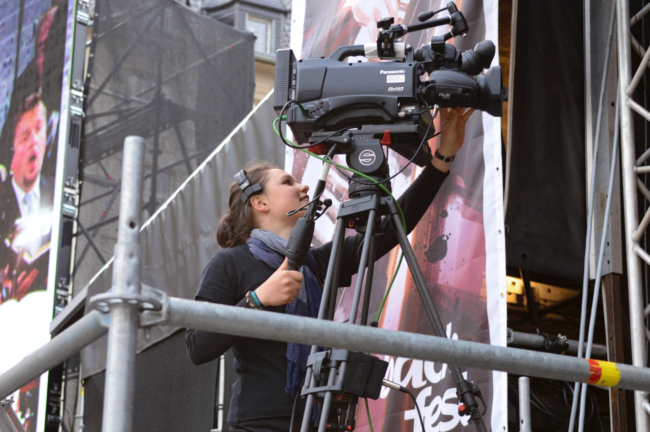 A student behind a camera at a live event
