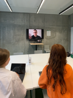 zwei Studentinnen halten im Gruppenarbeitsraum eine Videokonferenz