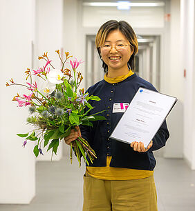 junge Japanerin mit Blumen und Urkunde