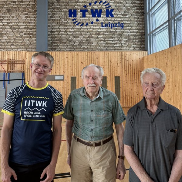 v. l.: Robert Schiffler, Horst Sahlmann (90), Hans Dachs (98, Leiter der "Brigade Kraft"; Foto: HTWK Leipzig) drei Herren in einer Sporthalle