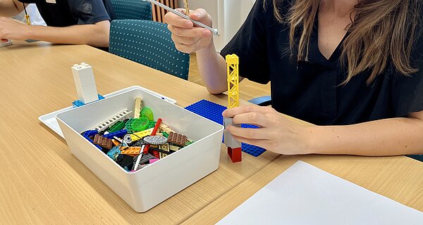 Bauprozess im Workshop Bauprozess: Eine Teilnehmerin baut ein Lego-Modell