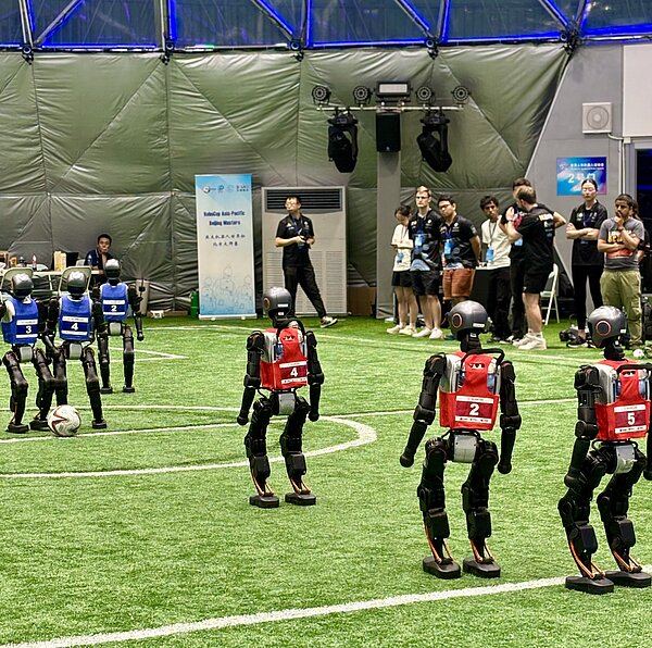 Menschenähnliche Roboter beim Fußballspiel.