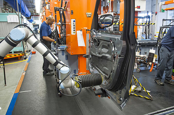 Mensch-Technik-Kooperation in einem BMW-Werk (BMW-Pressefoto) Menschen und Maschinen arbeiten in einer Produktionsanlage gemeinsam an der Fertigung von Fahrzeugen