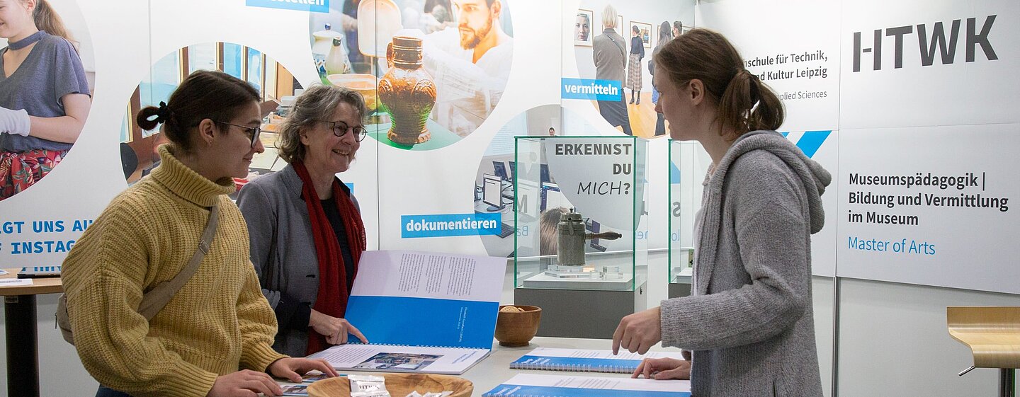 drei Frauen stehen an einem Tisch