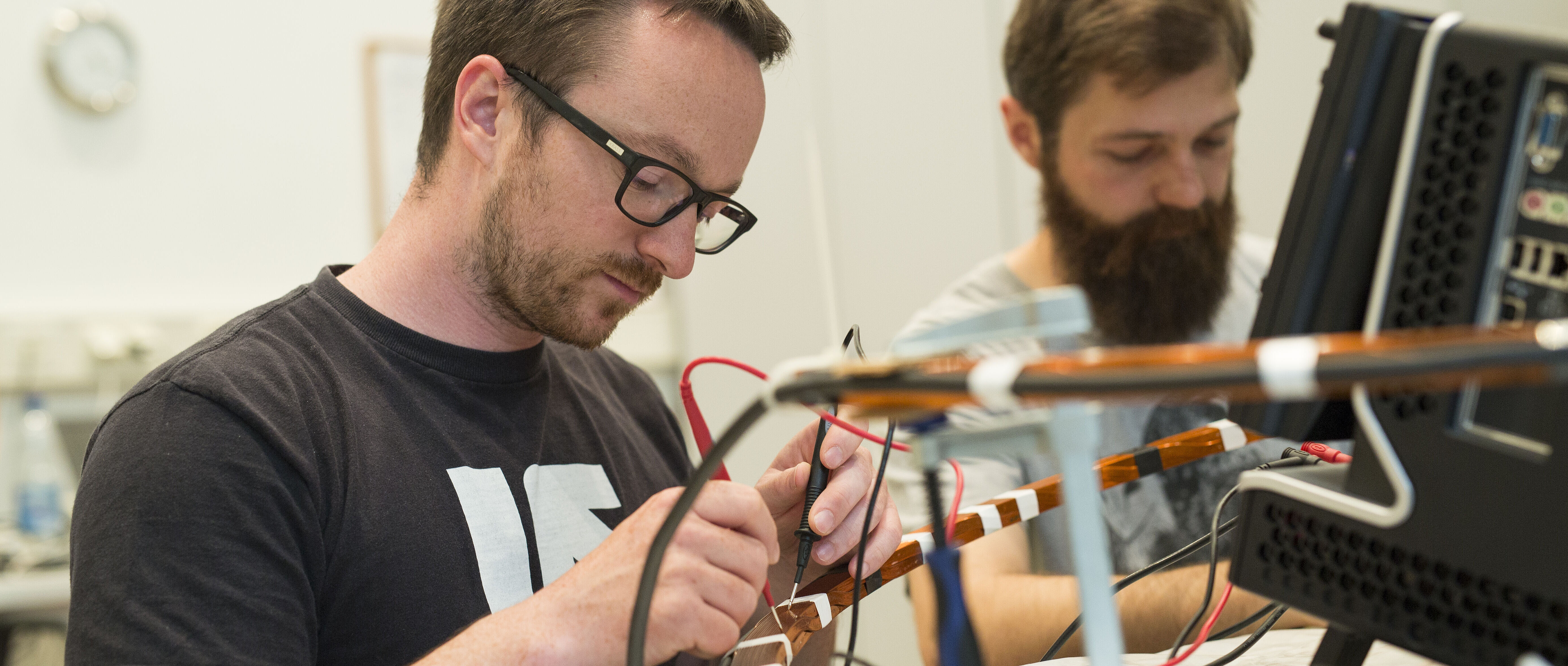 Zwei Studierende hantieren im Labor mit Messgeräten