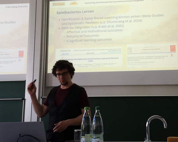 Dr. Nestler wird beim halten seines Beitrages zum Game Based Learning gezeigt. 