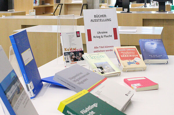 Bücher zu den Themen Ukraine und Krieg werden auf einem Tisch in der Bibliothek ausgestellt. 