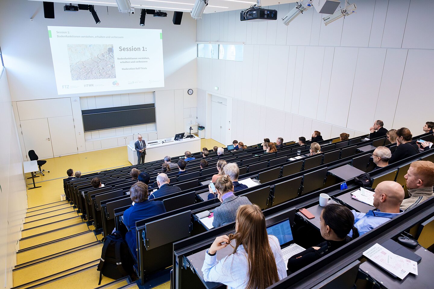 Menschen bei einer Tagung im Hörsaal