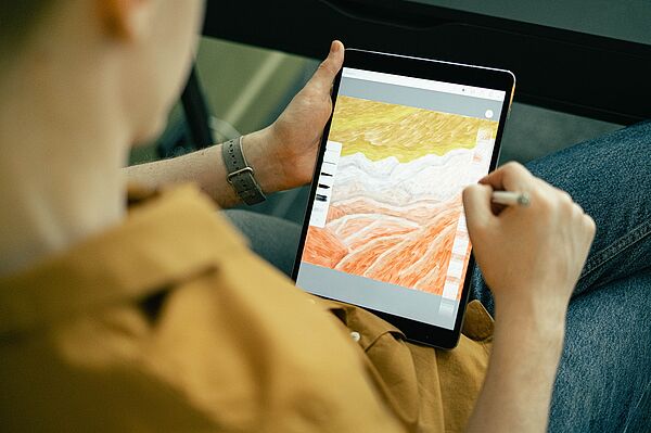 eine Person zeichnet ein Landschaftsbild auf ihrem iPad