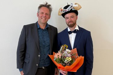 Portraitfoto mit Doktorhut und Blumenstrauß, links neben Johst steht Prof. Böhm