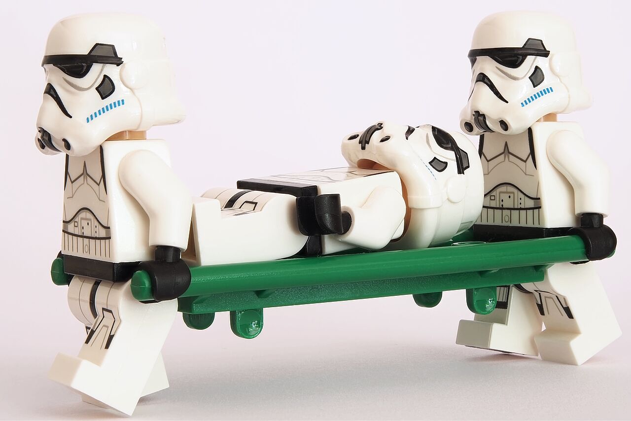 Zwei Lego Stormtrooper aus Star Wars transportieren auf einer Liege einen verletzten Kameraden