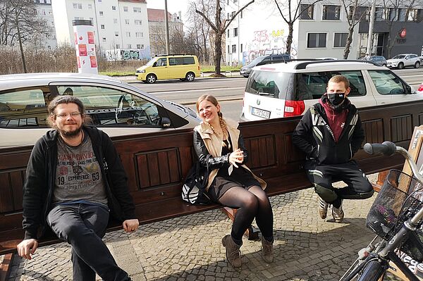 Lubo, Sabine und Jonas sitzen auf einer Parkbank