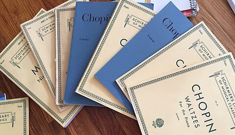 Musikbibliotheken Mehrere Notensammlungen liegen fächerartig auf einem Tisch.