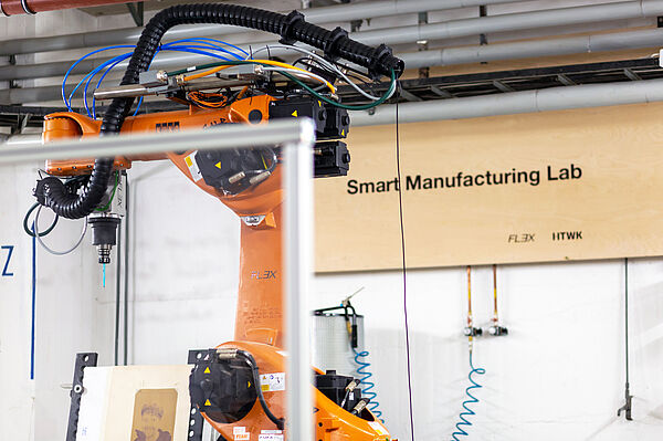 Blick in die Werkhalle auf den orangenen KUKA-Roboter