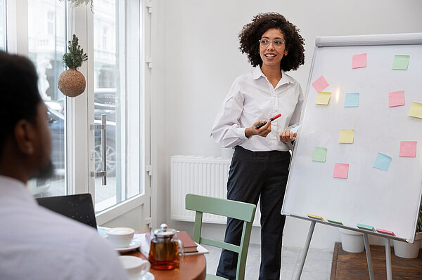 Wissenschaftlerin steht am Flipchart