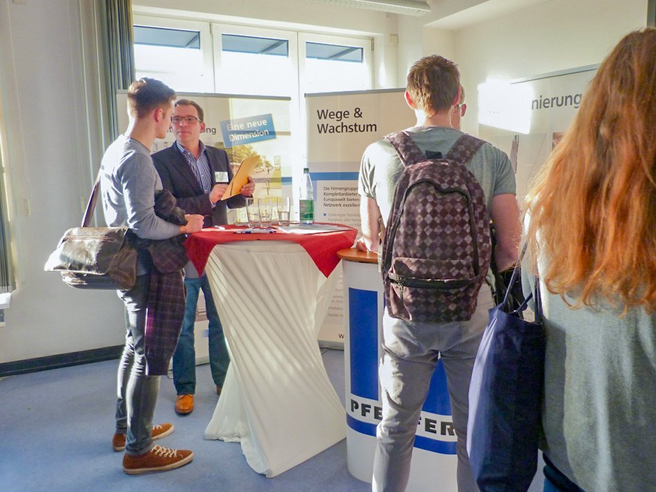Mehrere Firmenstände mit Vertretungen und interessierten Studierenden davor