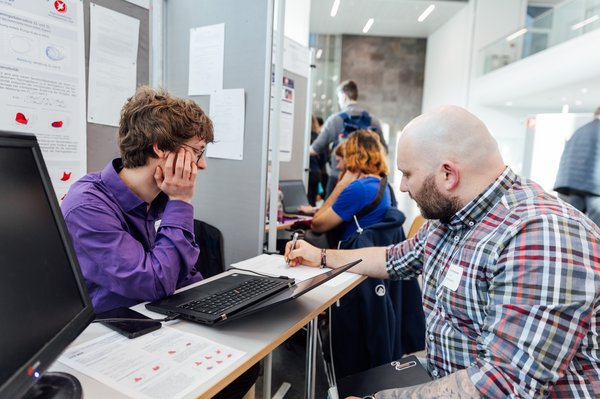 zwei Personen arbeiten gemeinsam an einem Tisch