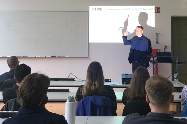 Prof. Krondorf an der Projektionsfläche eines Beamer zu sehen im Seminarraum, im Vordergrund Zuhörende