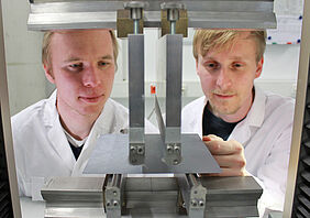 Professor Stephan Schönfelder (links) von der HTWK Leipzig und Felix Kaule vom Fraunhofer CSP am 4-Punkt-Biegeversuch mit einem polykristallinen Siliziumwafer