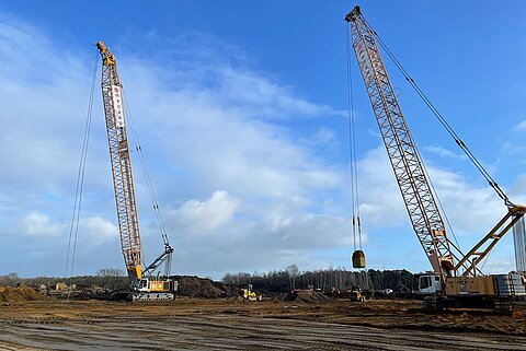 Zwei große Maschinen zur Bodenverdichtung auf einer Brachfläche