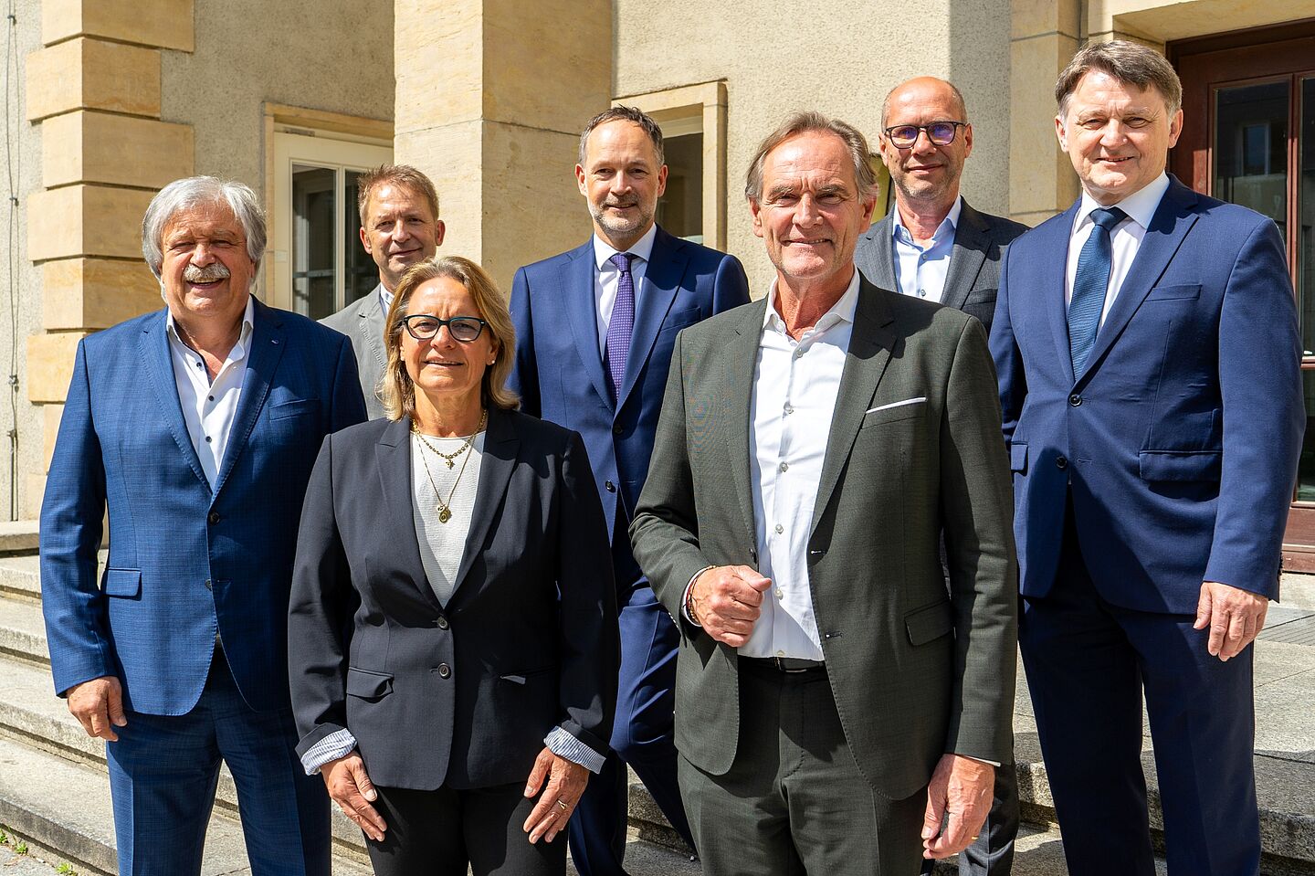 Gruppenbild mit lächelnden Hochschulratsmitgliedern am Eingang eines HTWK-Gebäudes