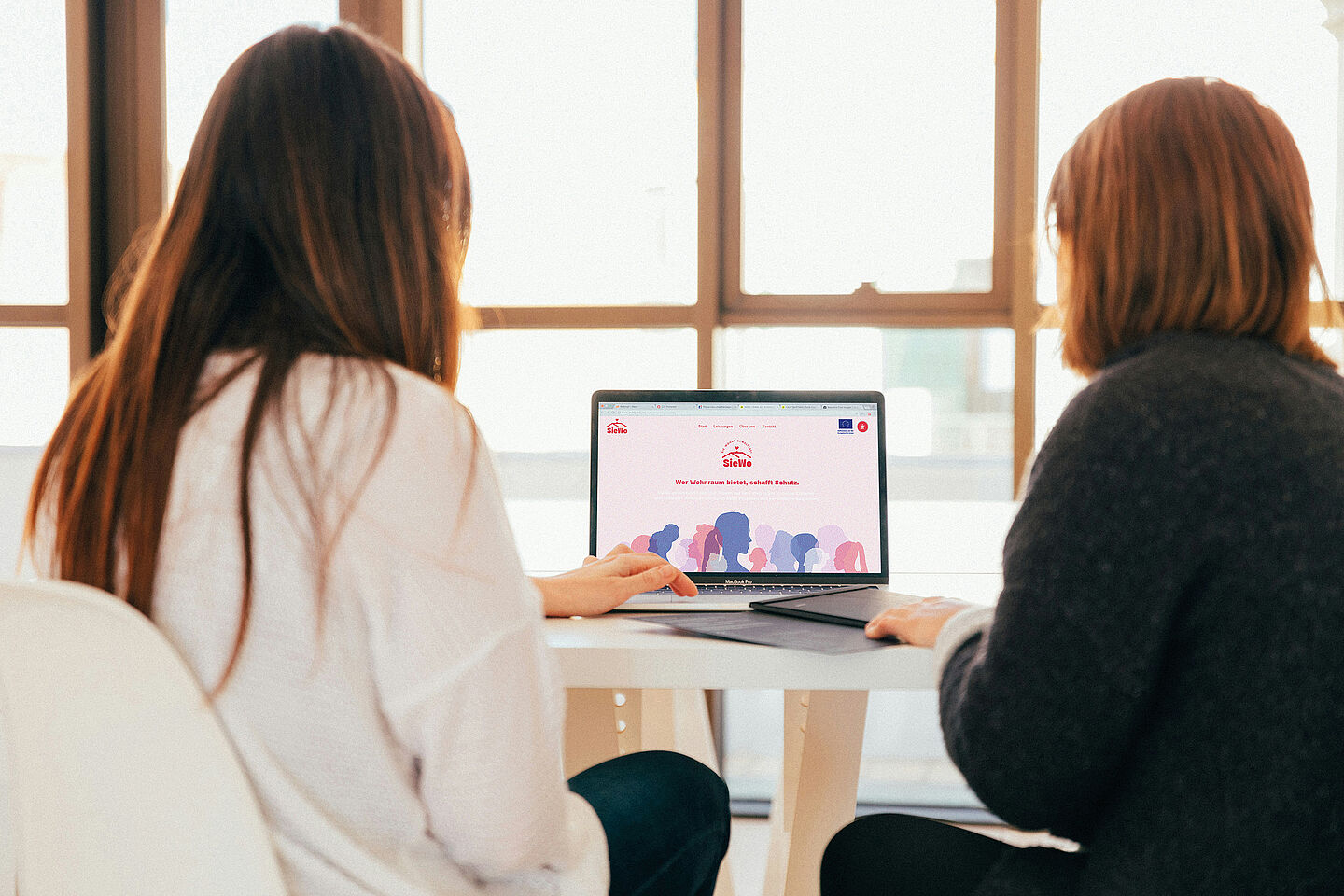 zwei Frauen sitzen am Laptop