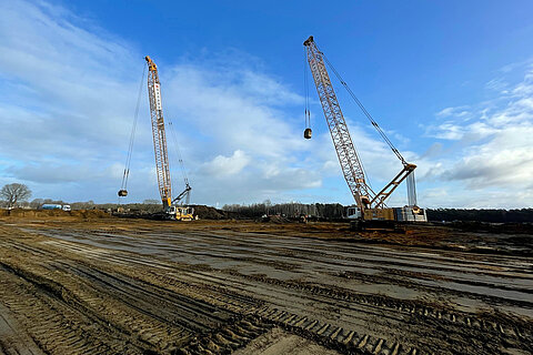 Zwei Kräne stehen auf dem Baugrund