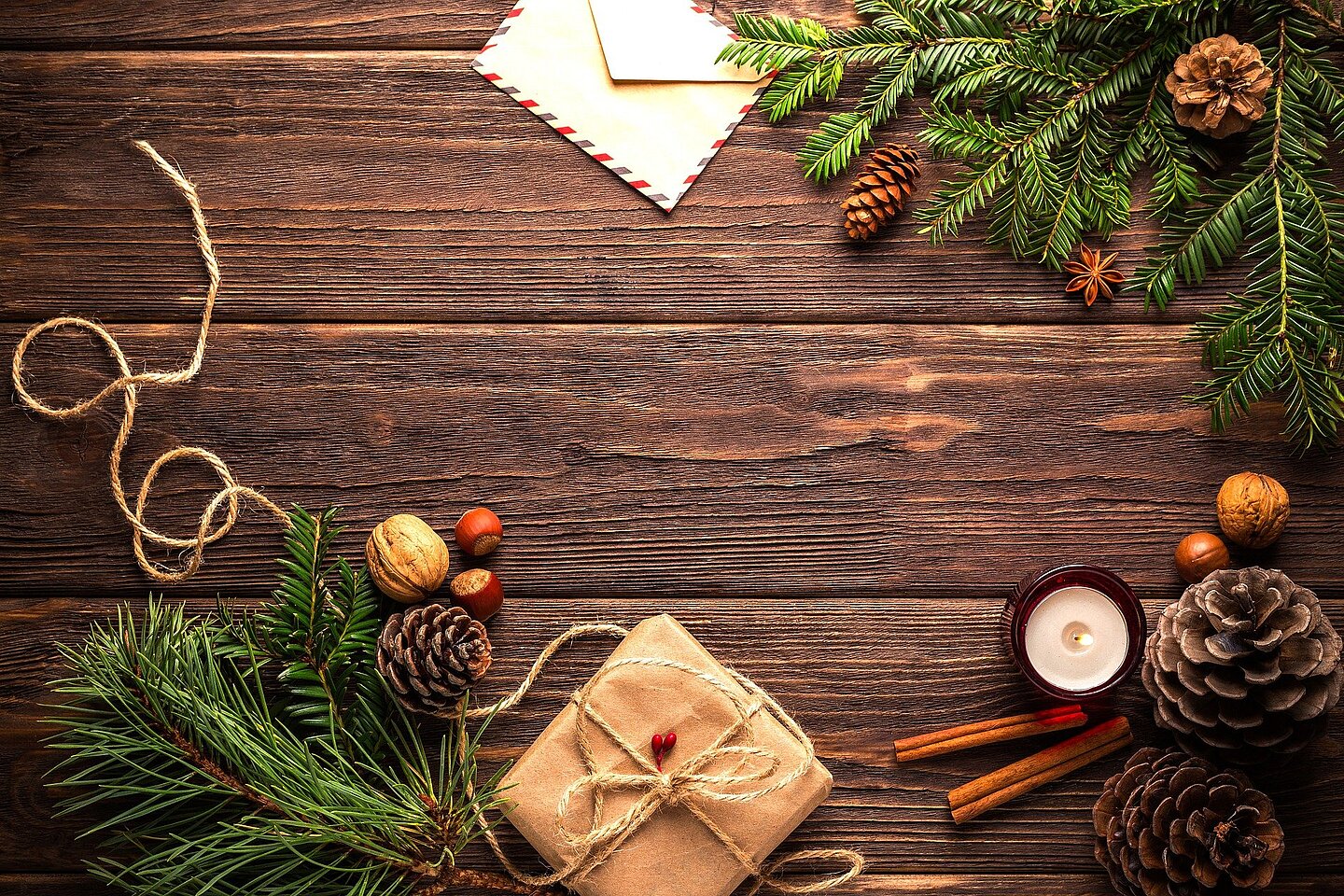Verpackung und Deko aus Natur- oder Recycling-Materialien machen Geschenke individuell. (Foto: Daria Jakowlewa/pixabay) Holzbohlen mit Tannengrün, Nüssen und einem Geschenk