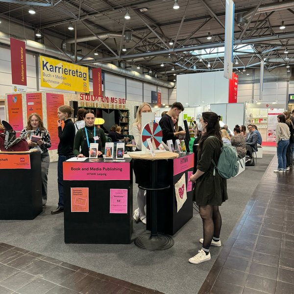 Menschen stehen an einem Messestand
