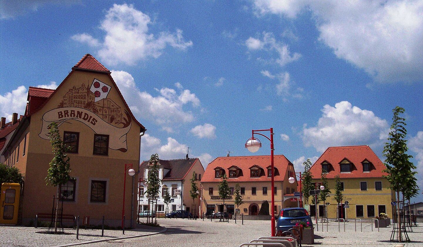 Marktplatz in Brandis (Foto: Isabell Engisch) Blick auf den Marktplatz der Stadt Brandis im Sonnenschein, leicht bewölkter Himmel.