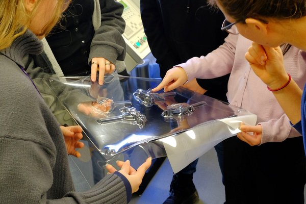 Ferienhochschule Eisformen (Foto: HTWK Leipzig) Draufblich auf drei Personen, die eine durchsichtige Folie mit Formen betrachten