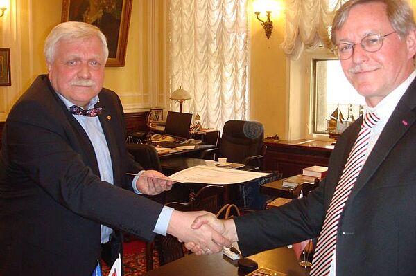 Prof. Klaus Holschemacher schüttelt dem Akademiepräsidenten Aleksandr Kuzmin die Hand