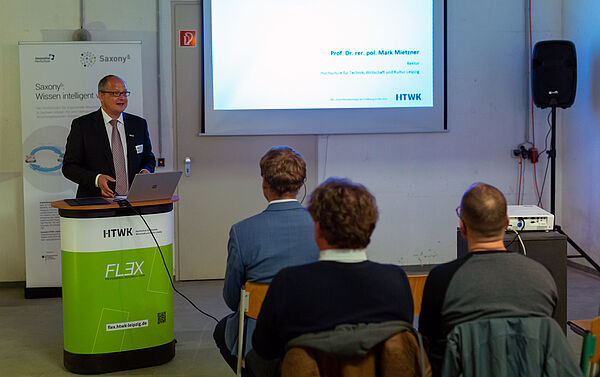 HTWK-Rektor Prof. Mark Mietzner steht am Rednerpult und begrüßt die Gäste der Transferveranstaltung Forschung trifft ...