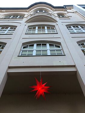 roter Weihnachtsstern hängt von Gebäude