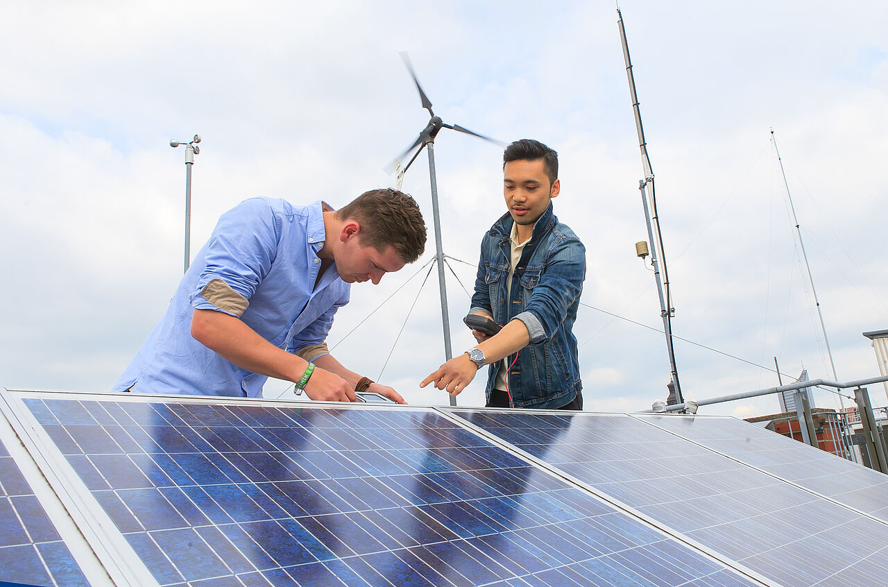 Zwei Männer reparieren eine Solarzelle