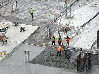 SlideTex Six construction workers at the construction site, seen from a bird's-eye view
