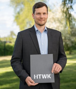 Dissertationspreis 2024 Preisträger hält die Urkunde des Dissertationspreises in der Hand