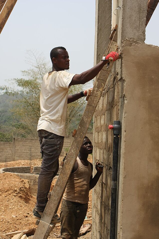 Bild von den Bauarbeiten an der Zisterne mit zwei einheimischen Arbeitern.