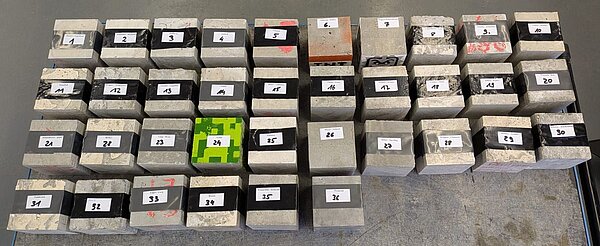 35 Betonwürfel liegen zur Prüfung mit der höchsten Druckfestigkeit