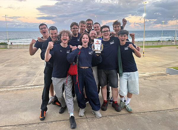 Die Informatiker der HTWK Leipzig am Strand von Salvador mit dem Pokal in der Hand