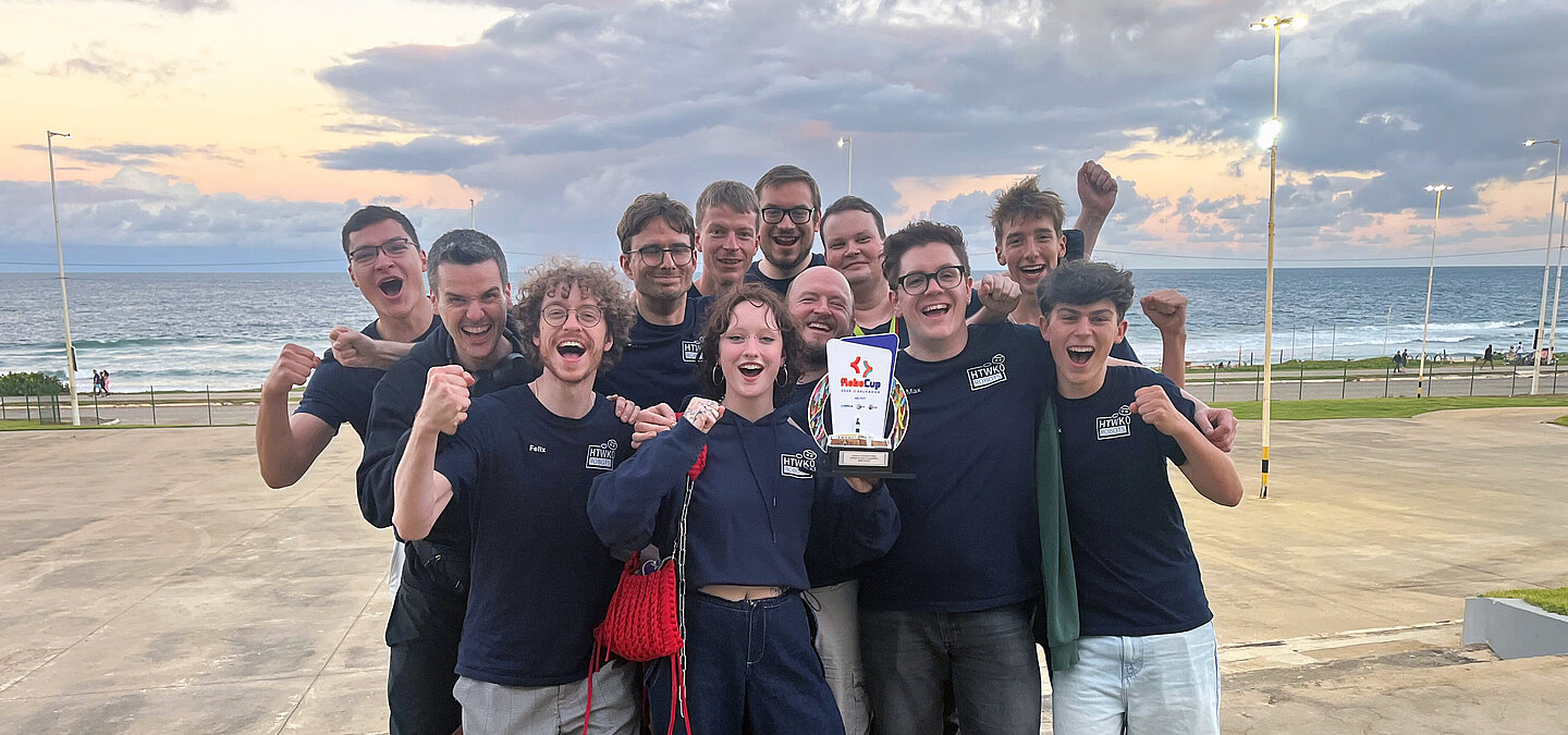 Die Informatiker der HTWK Leipzig am Strand von Salvador mit dem Pokal in der Hand