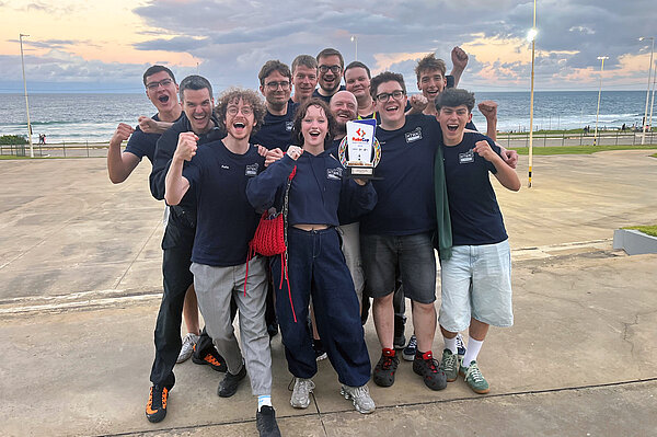 Die Informatiker der HTWK Leipzig am Strand von Salvador mit dem Pokal in der Hand