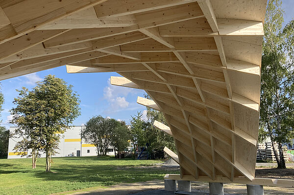 In Leipzig-Engelsdorf steht ein Demonstrator von Timber Plan Plus, ein Nachfolgemodell des Zollingerdachs, auf einer Wiese.