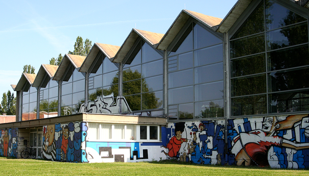 Seitlich fotografierter Haupteingang der Sporthalle der HTWK Leipzig.