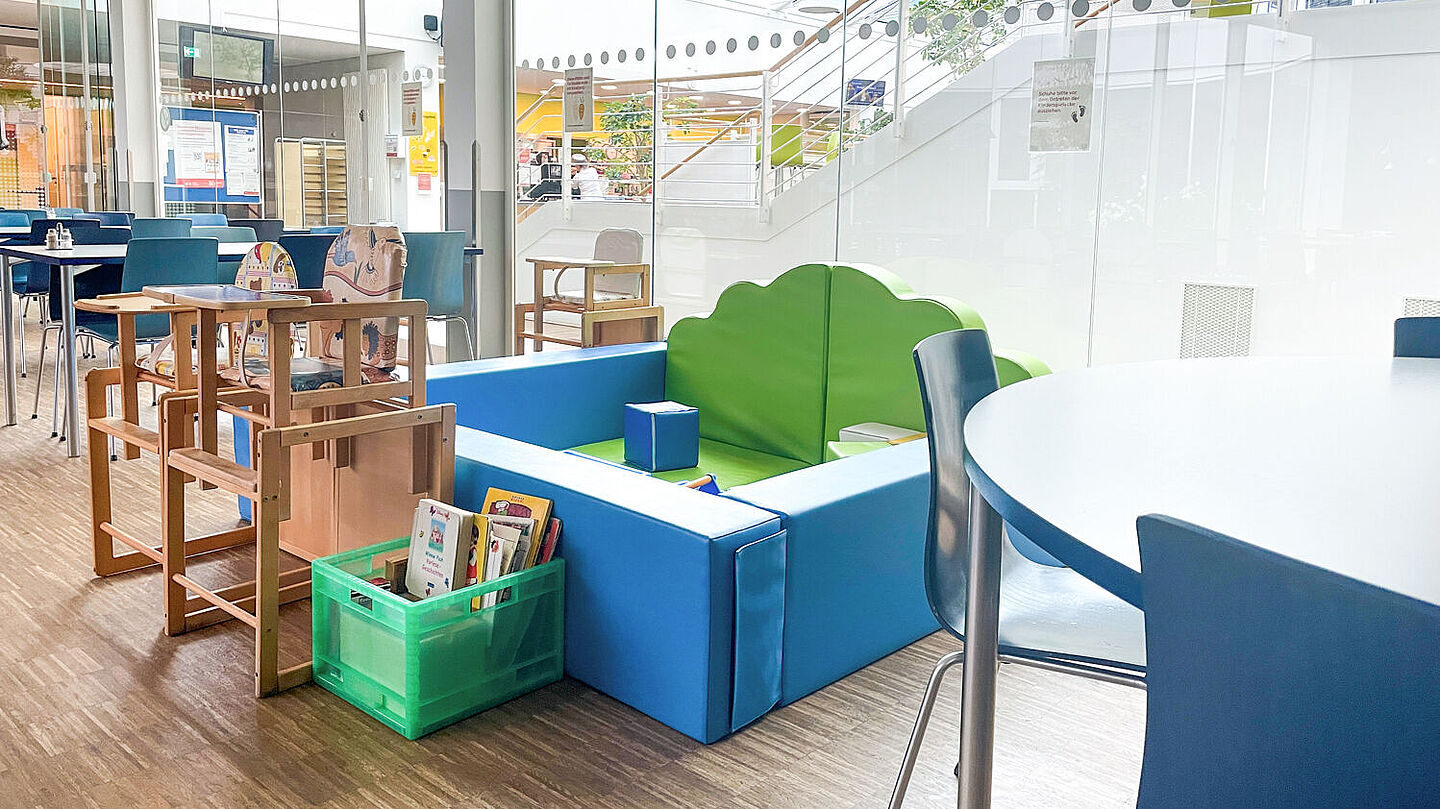 Die Kinderecke in einem abgetrennten Bereich mit Schaumstoffwänden, Büchern und verschiedenen Spielzeugen.