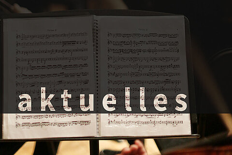 Über das Bild eines aufgeschlagenen Notenhefts wurde per Computer das Wort "aktuelles" gelegt.