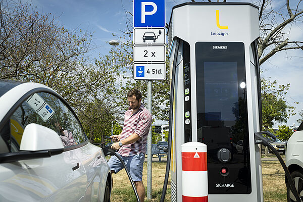 Viktor Woldd von Taubert Consulting lädt sein Elektroauto an der HPC-Ladestation.