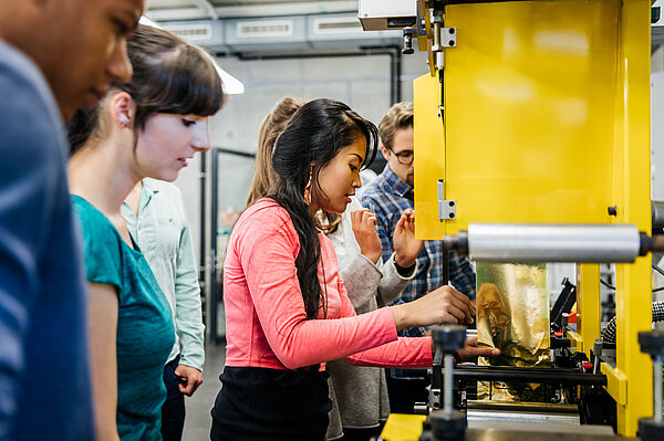 Students work independently on large printing presses