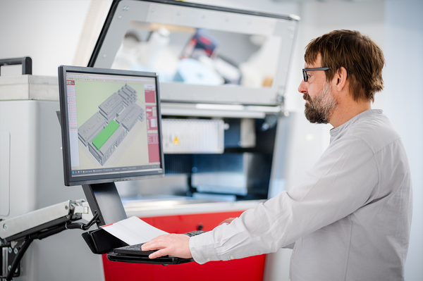 Prof. Dr. Ingo Reinhold arbeitet in einem Labor an einem Rechner, auf dessen Bildschirm ein CAD-Modell abgebildet ist. 