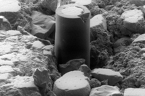 Untersuchungen zur Verbundzone zwischen faseroptischen Sensoren und Baustoffen Nahaufnahme eines Zementmörtels eingebettetet in faseroptischen Sesoren und Baustoffen